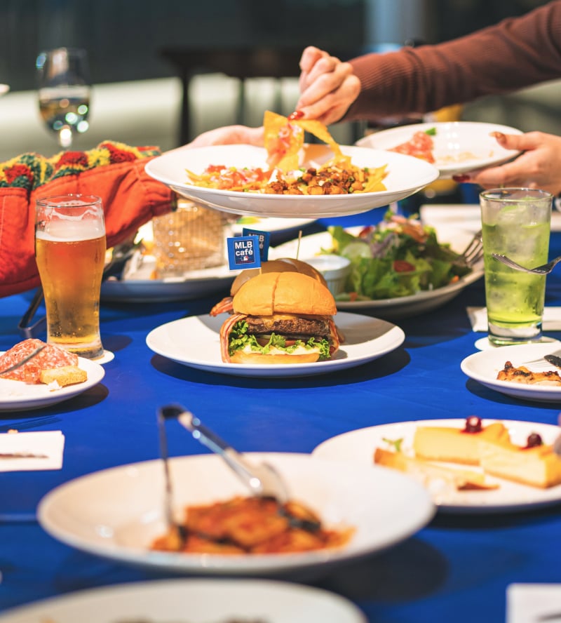 写真: MLB BIGバーガーを中心にテーブルに並ぶ料理
